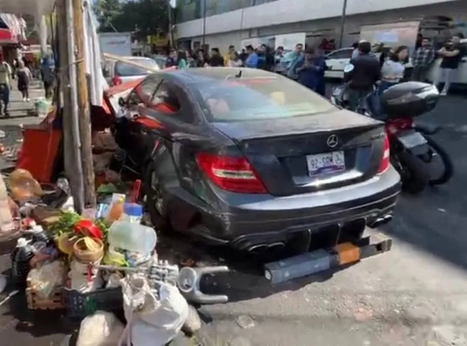 Joven choca su Mercedes Benz contra puestos de comida