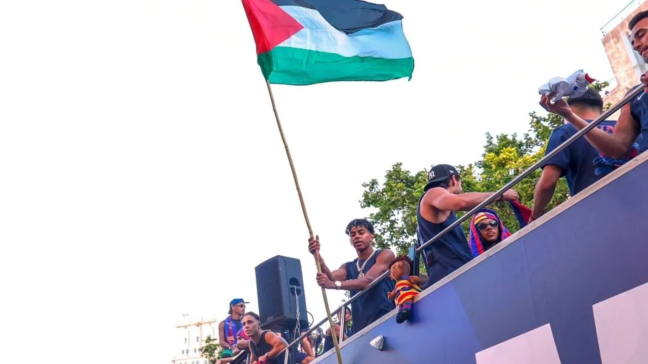 Lamine Yamal ondea la bandera palestina durante el desfile de celebración del título del Barcelona